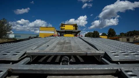 Low angle shot of empty metal car transporter truck bed under blue sky with.. Photos