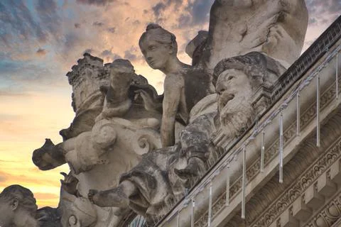 A low angle shot of eroding sandstone statues against a cloudy sunset sky in  Foto stock