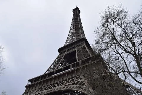 Low-angle shot of the famous Eiffel tower in Paris against the cloudy sky during Stock Photos