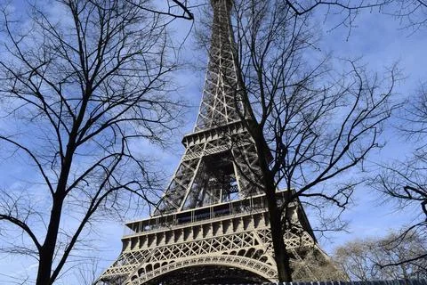 Low angle shot of the famous Eiffel tower in Paris against the blue sky during t 스톡 사진