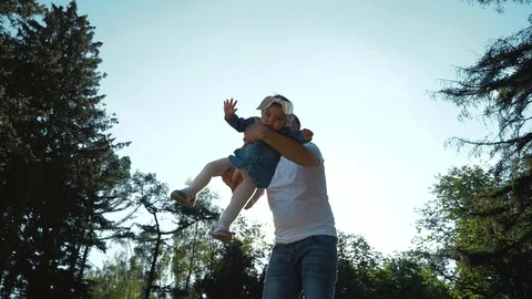 Low angle shot of father playing with toddler daughter in summer park Stock-Footage 108298403