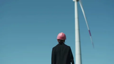 Low angle shot of female engineer standing in the middle of the windmill Stock Footage 238008990