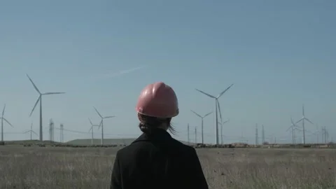 Low angle shot of female engineer standing in the middle of the windmill Stock Footage 238009816