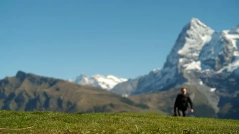 Low angle shot with focus on a grass and blurred figure of a man Video stock 201164983