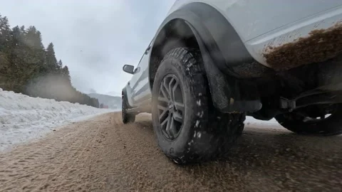 Low angle shot of a Ford Ranger Raptor pickup truck car driving on a snowy road Video stock 169947140