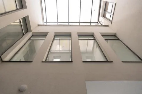 Low angle shot of geometric glass panes and light through a contemporary atri Stock Photos