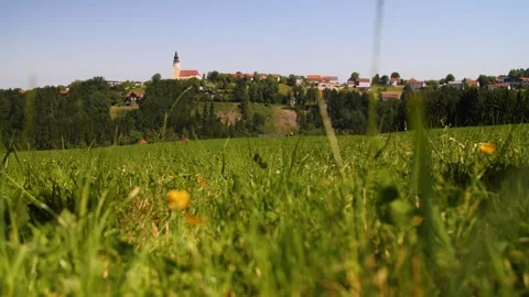 A low angle shot of grass in front of a small Austrian village 1 Stock Footage 157856632