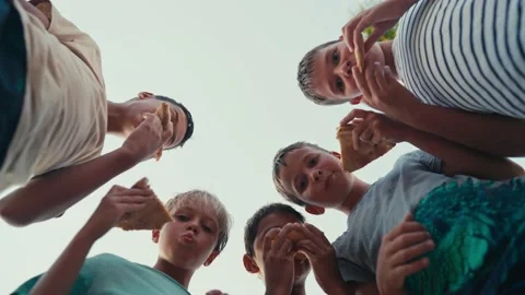 Low angle shot group of children friends picnic eat pizza sit on park grass Stock Footage 203854121