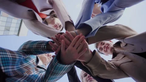 Low-angle shot of a group of friends, all dressed in stylish outfits, putting Stock Footage 297468306