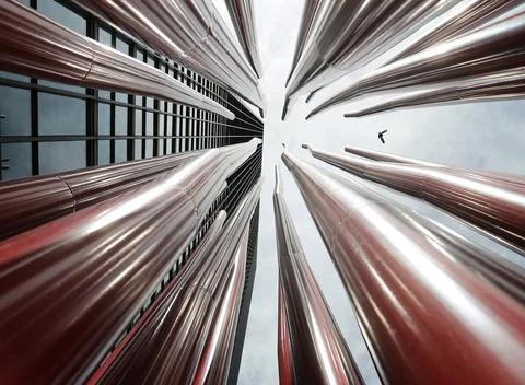 Low angle shot of a group of red, metal tubes near a building Stock Photos
