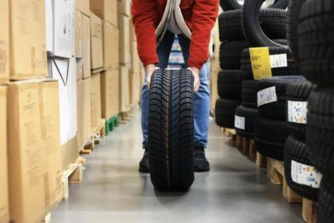 Low angle shot of a guy in a red jacket and jeans holding or carrying a new.. Stock Photos