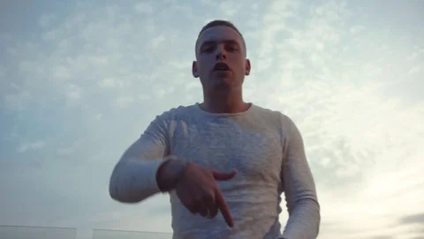 Low angle shot of handsome young Caucasian man rapping and actively Stock Footage 112673972