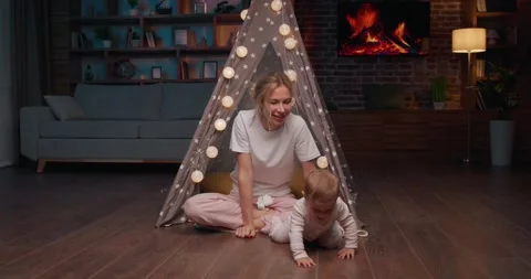 Low angle shot of a happy small girl crawling on the floor at cozy living room. Stock Footage 242178529