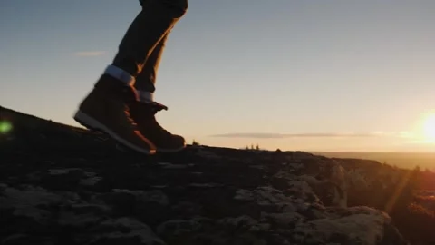 Low angle shot of hiker legs walking on rocky mountain peak trail during go.. Stock Footage 334543590