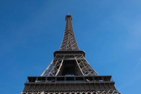 A low angle shot of the historic Eiffel Tower in Paris on a blue sky backgrou Photos