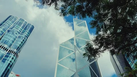 A low-angle shot of Hong Kong skyscrapers against partly cloudy skies, Stock Footage 338311536