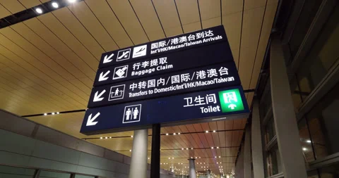 Low-angle shot of illuminated overhead wayfinding sign at Chinese airport Video stock 329460602