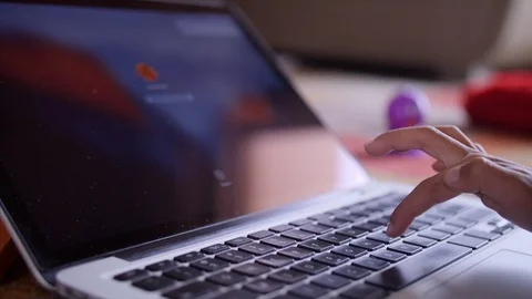 Low angle shot of an Indian kid entering password to unlock his laptop screen Video stock 114054919