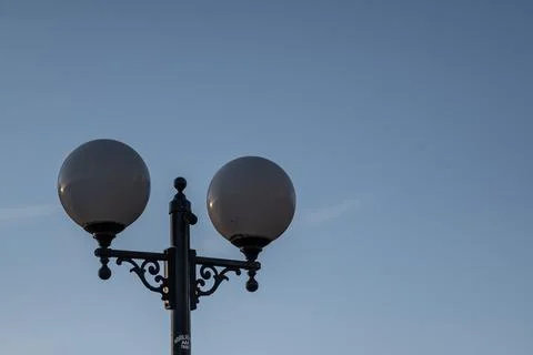 Low angle shot of a lamp with round lights in a blue sky Stock Photos