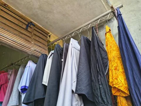 Low-angle shot of laundry hanging to dry on a metal rack. Stock Photos