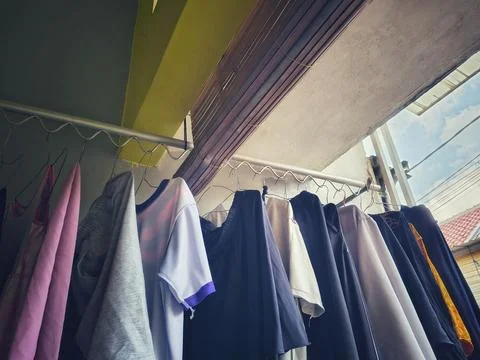 Low-angle shot of laundry hanging to dry on a metal rack. Stock Photos