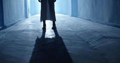 Low angle shot of legs of little girl ghost slowly creeping on floor of hallway Stock Photos