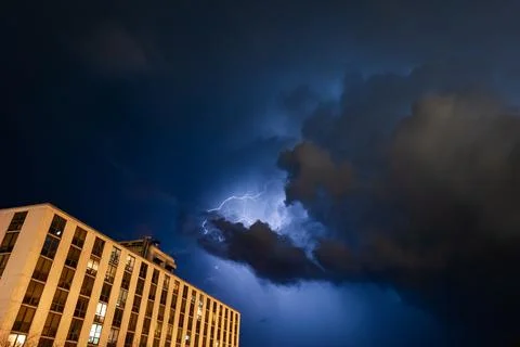 Low angle shot of the lightning storm with a building in the foreground Fotos de archivo