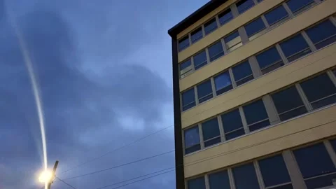 Low angle shot looking up at a large empty, office building on a cloudy Stock Footage 273430759