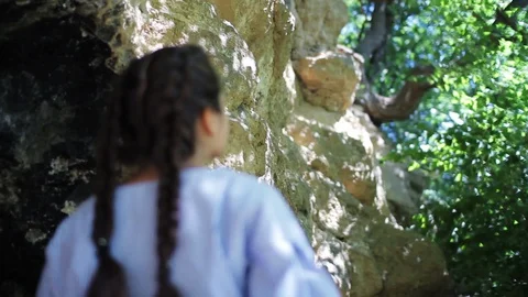 Low angle shot of lovely young woman with two braids looking round while Stock Footage 99310325