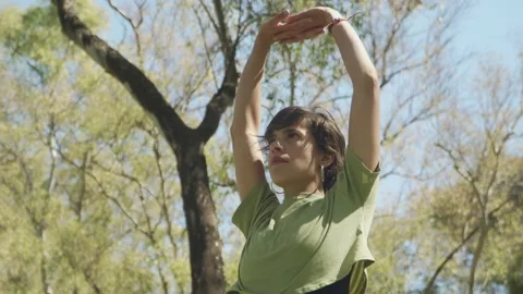 Low angle shot of a lovely young woman doing yoga exercises at park Stock Footage 140347641