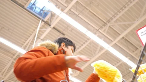 Low angle shot man loads shopping cart with corn ball packs Stock-Footage 102606713