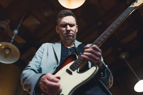 Low-angle shot of a man playing electric guitar Stock Photos