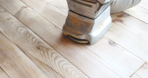 A low angle shot of a man sanding a parquet with a parquet sanding machine Stock Footage 55327886