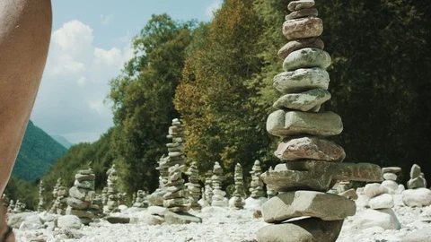 Low Angle Shot Of A Man Walking Along A Stone Sculptures In A Dry Riverbed Stock Footage 94032120