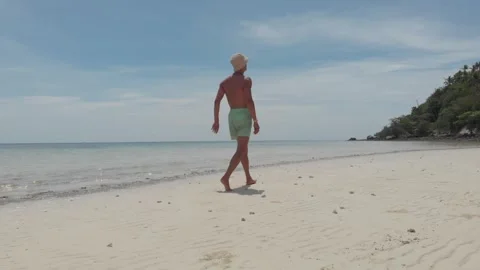 Low Angle shot of a Man Walking on a Beach Vidéo 260431039