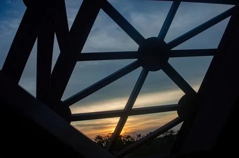 A low angle shot of a metal structure with geometric design against a sunse.. Stock-Fotos
