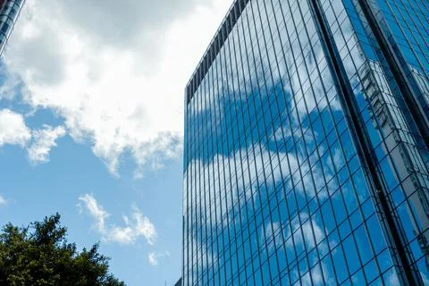Low angle shot of a modern building with glass facade with the reflection of the Foto stock