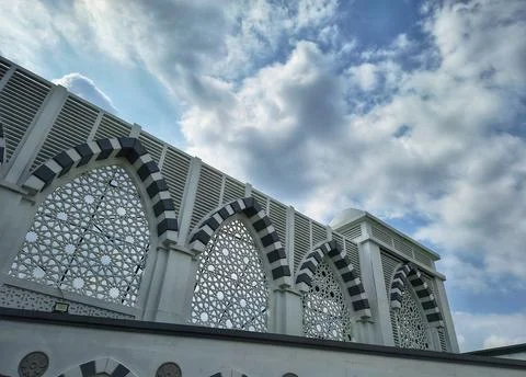 Low angle shot of a mosque's white exterior with intricate geometric screens Stock Photos