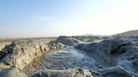 Low angle shot of mud exploding out of the earth at the Mud Volcanoes in Stock Footage 100349288