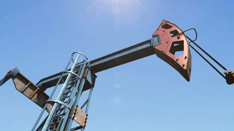 Low angle shot of oil pump jack pumping crude oil under clear blue sunny sky Stock Footage 126436152