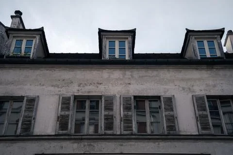 Low angle shot of an old building with three dormer window under sunset sky in P Stockfoto's