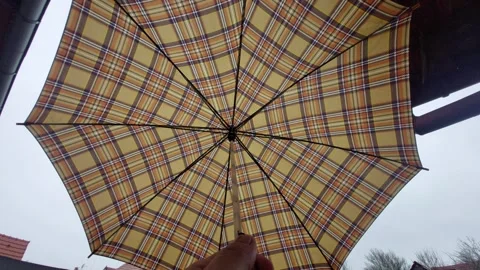 Low Angle Shot of Opening Plaid Umbrella Against Overcast Sky Vídeos de archivo 333642456