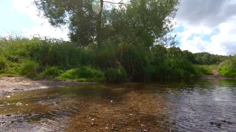 Low angle shot over a small river in UK countryside 動画素材 112629567
