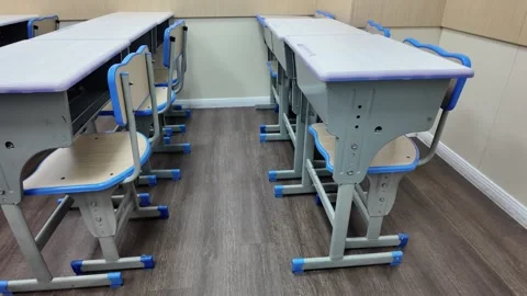 Low-Angle Shot of Parallel Rows of Desks and Chairs in Empty Classroom Stock Footage 339326866