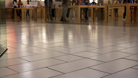 Low angle shot of people playing new iphone inside the Apple store Stock Footage 116098555