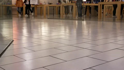 Low angle shot of people playing new iphone inside the Apple store Stock Footage 116138467