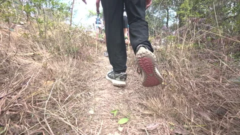 Low angle shot of people walking along a trail Видео 303943537