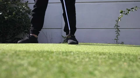 Low angle shot of person putting golf ball on green artificial turf outdoors Stock Footage 314118200