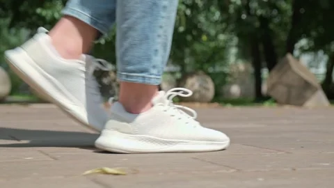 Low angle shot of a person wearing casual clothes and white running sneaker.. Stock Footage 339861388