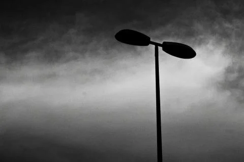 Low angle shot of a post lamp in black and  white with a cloudy background Fotos Stock